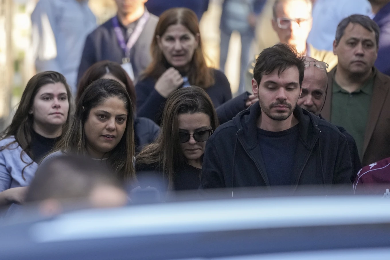 Thalita Valente Machado, bottom center, leaves Penha Cemetery after burying her husband Danilo Santos Romano in Sao Paulo, Brazil, Monday, Aug. 12, 2024. Romano was the pilot of the plane that crashed into the backyard of a home in the city of Vinhedo on Aug. 9